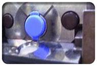 Blue vial inside machine with cap on